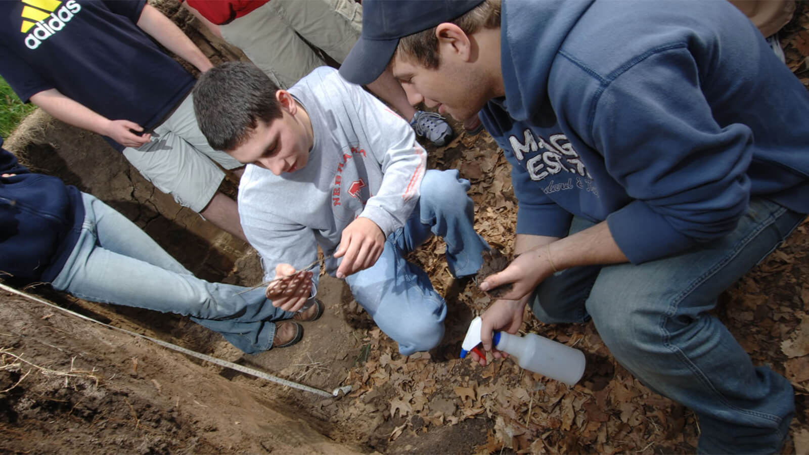 A group of students examine soil